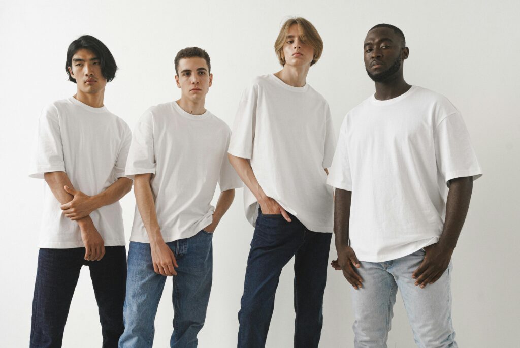 A diverse group of men standing in a row, all wearing white shirts.