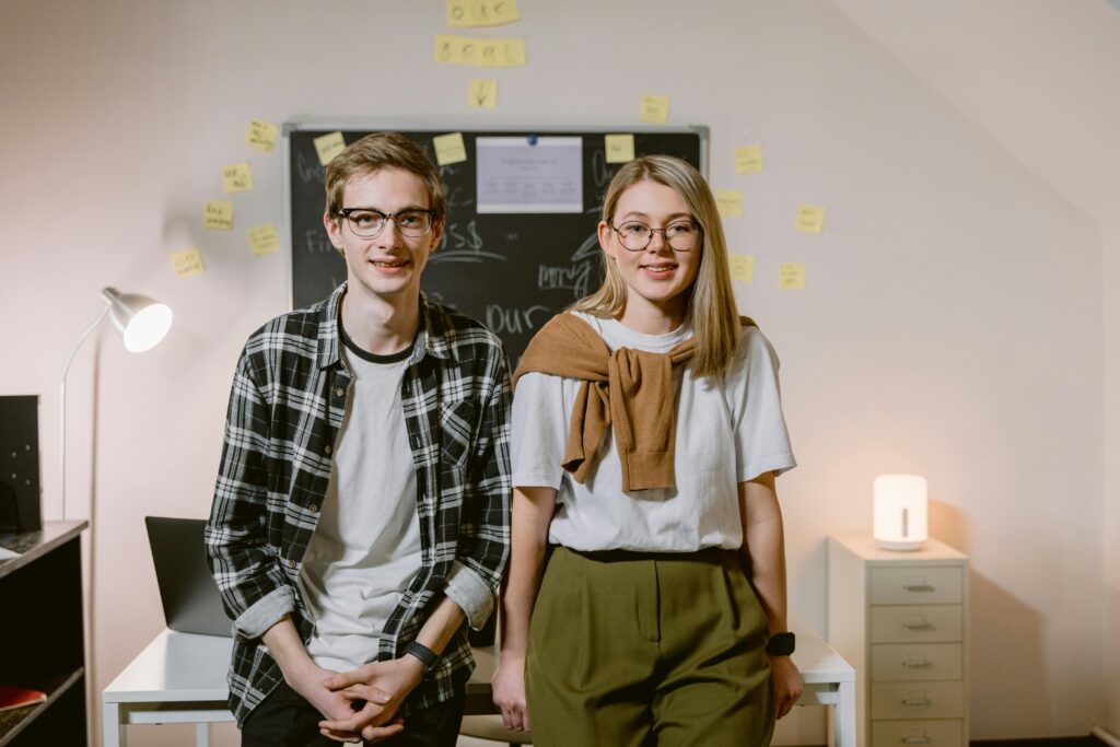 young couple sitting side by side, wearing clothes that may indicated their challenging traditional gender roles.
